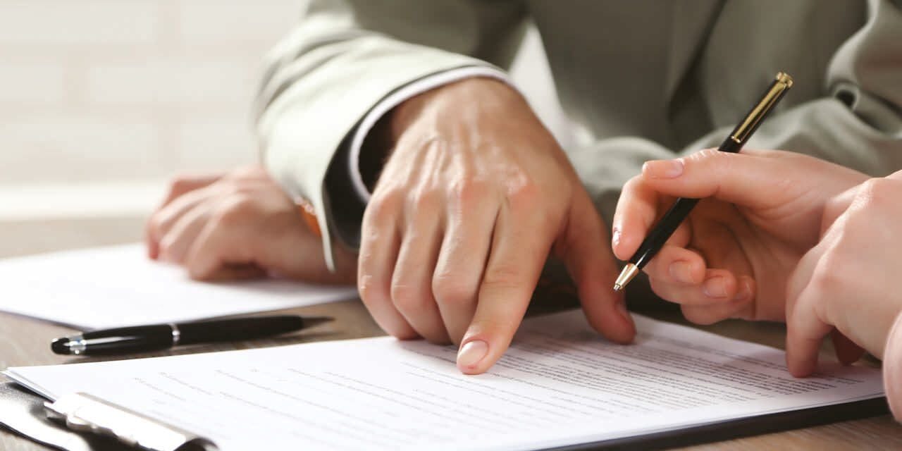 Jennifer Gastelum Law – Attorney Las Vegas A person is writing on paper with a pen.