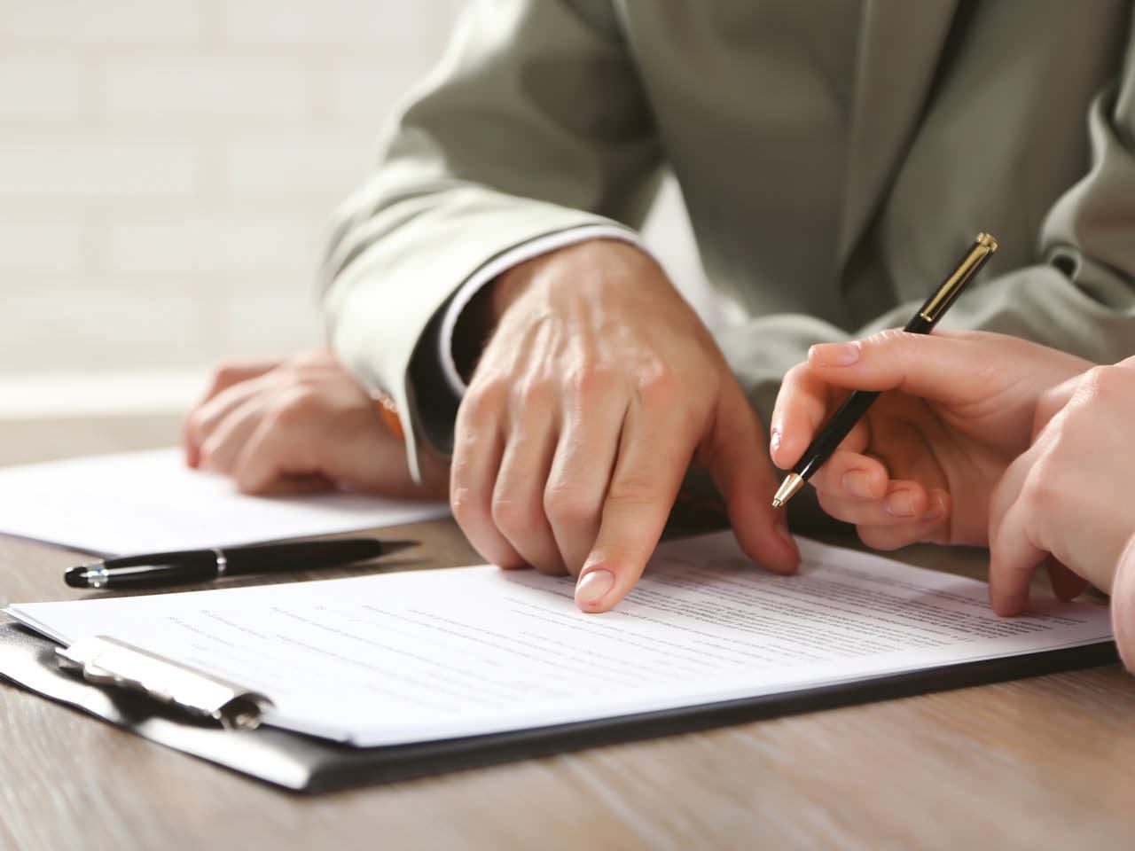 A person is writing on paper with a pen.