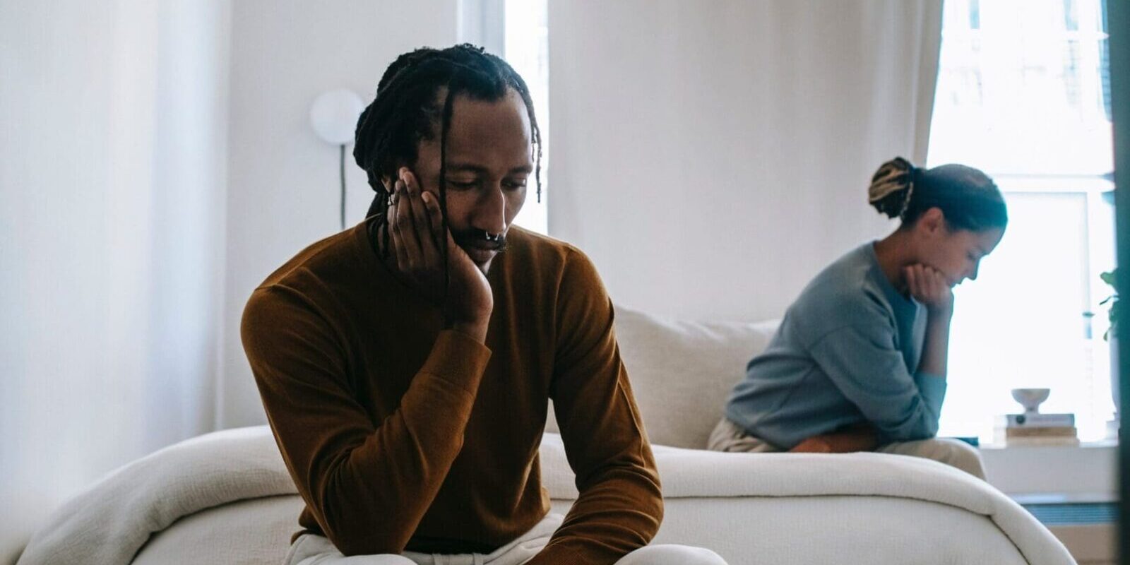 A man sitting on top of a couch next to another person.