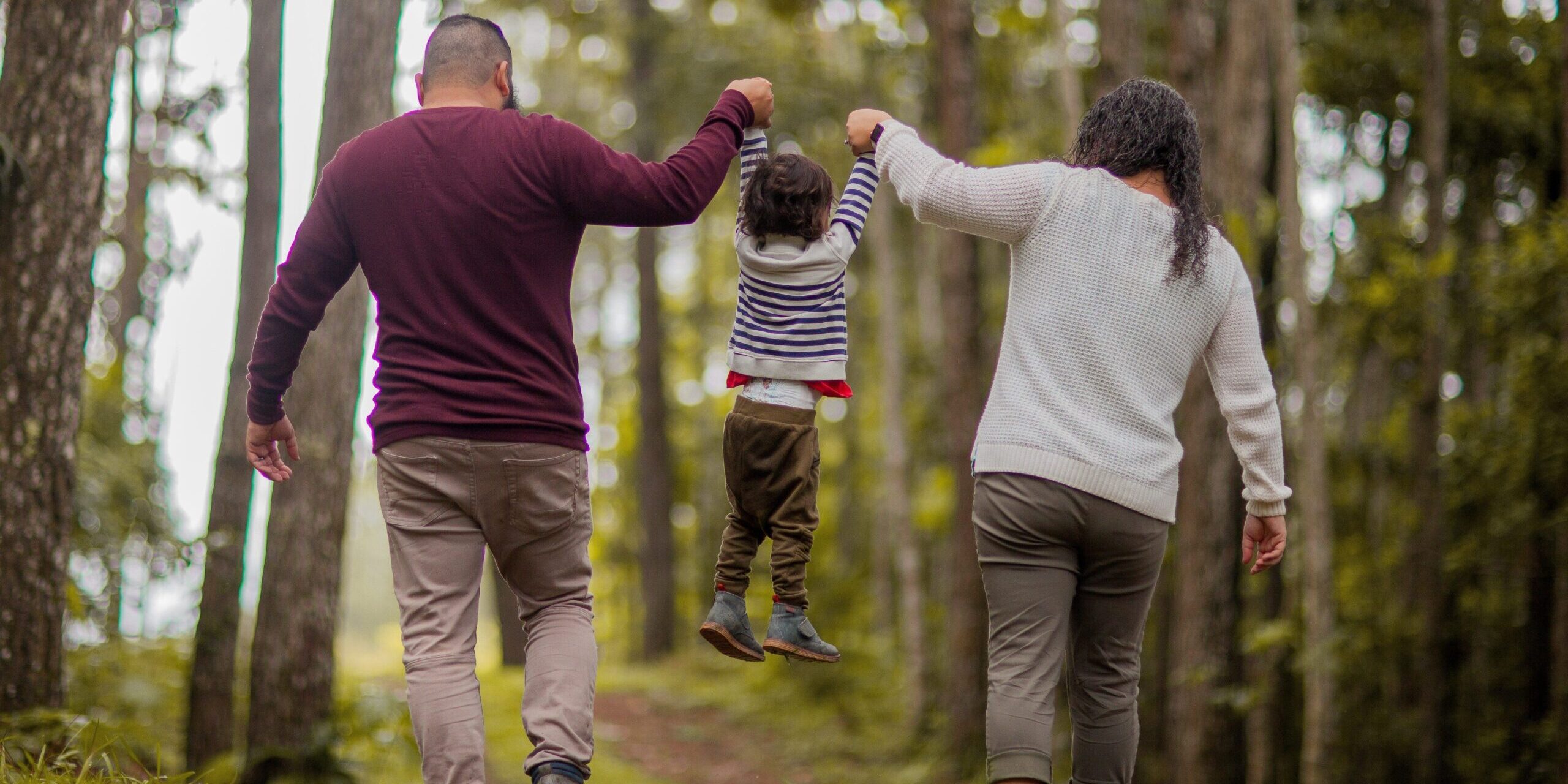 Schooling Stability during Divorce A man, woman and child walking through the woods.