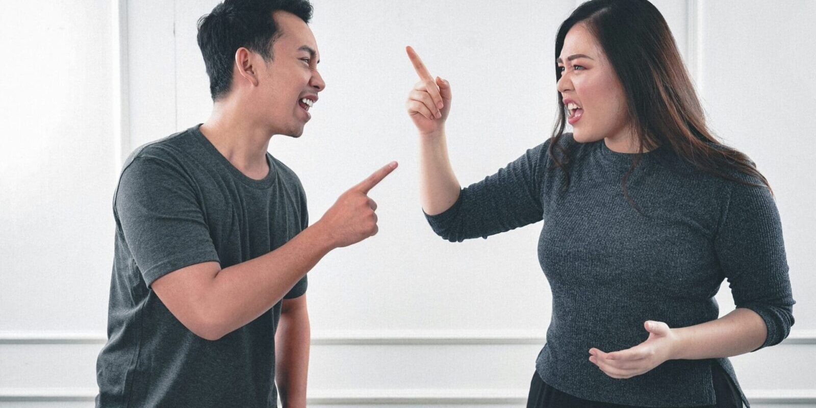 Two people arguing, pointing fingers intensely.