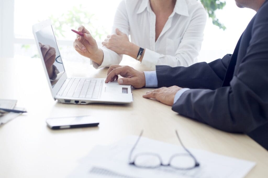 A group of people sitting at a table with laptops.