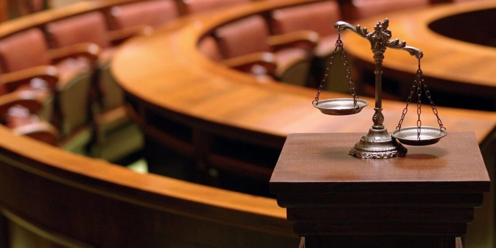 A wooden table with a scale and a gavel on it.